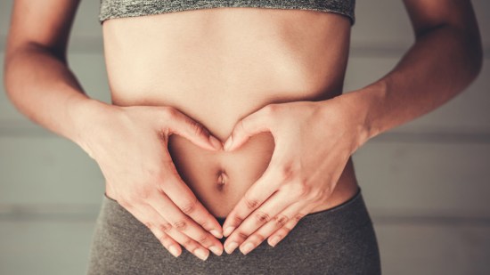 Mujer con manos en el abdomen