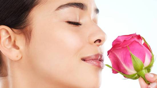 Mujer oliendo una rosa