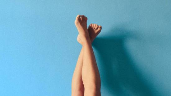 Piernas con varices apoyadas en una pared