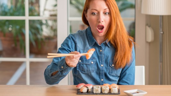 Mujer pelirroja comiendo sushi
