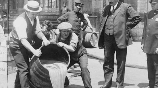 Ley seca. Hombres tirando el contenido de un barril lleno de alcohol