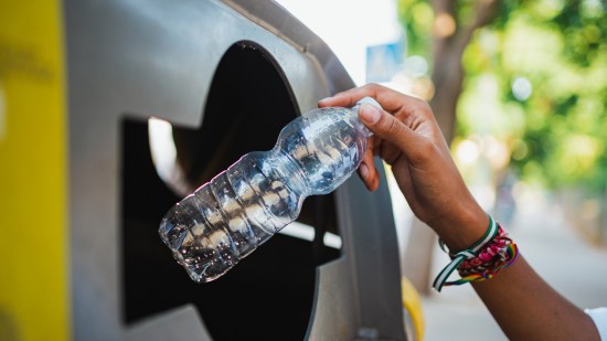Mujer reciclando una botella