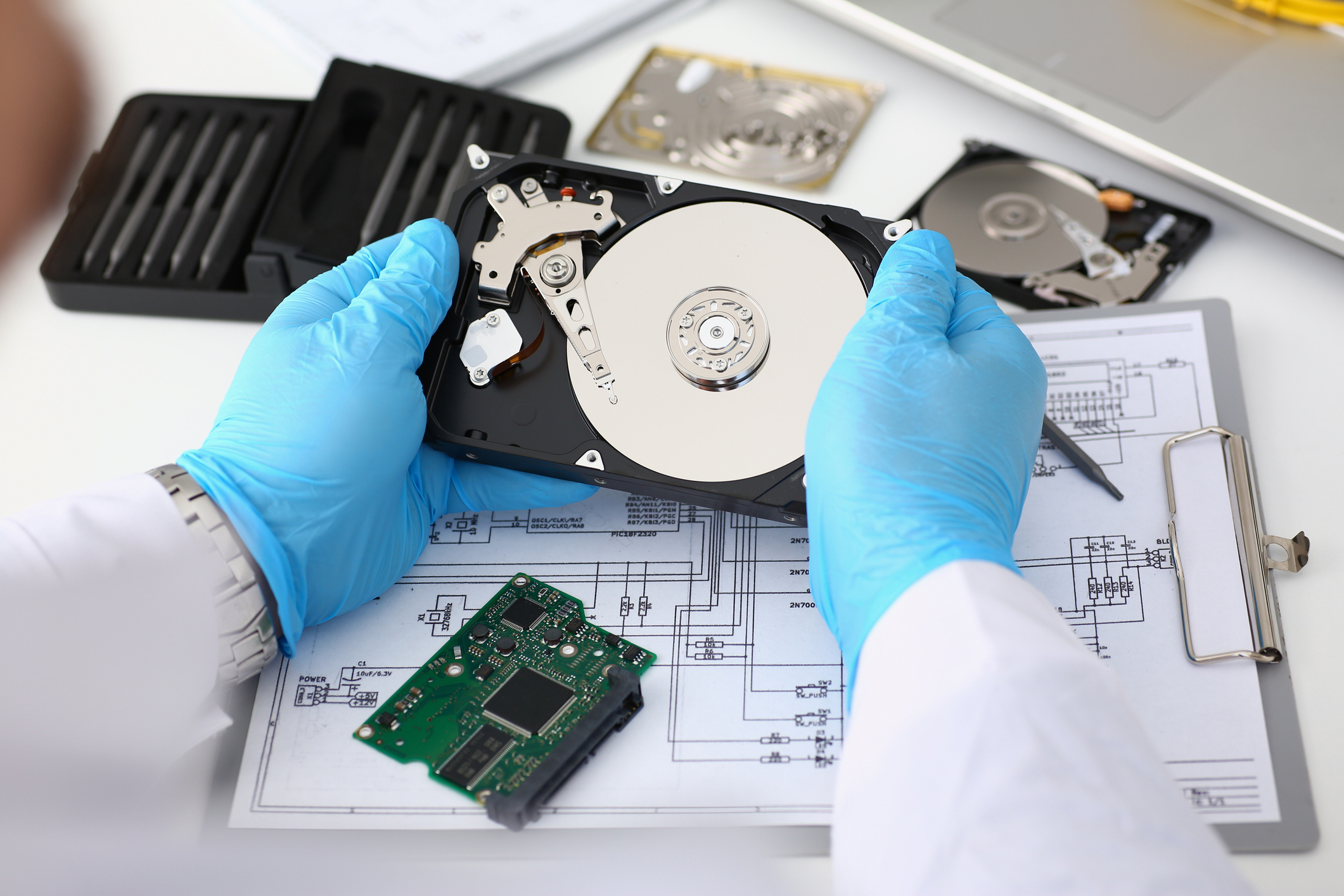 Technician repairs computer hard drive from motherboard.