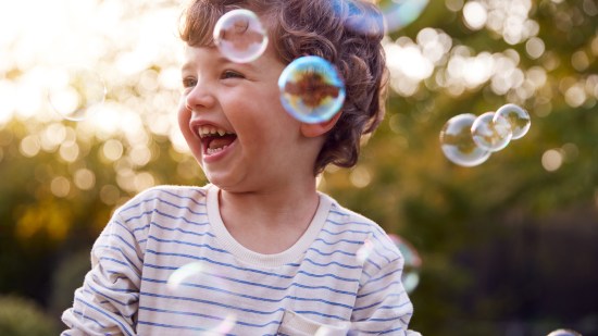 Niño riendo pompas