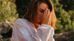 Mujer rezando cerca de un bosque