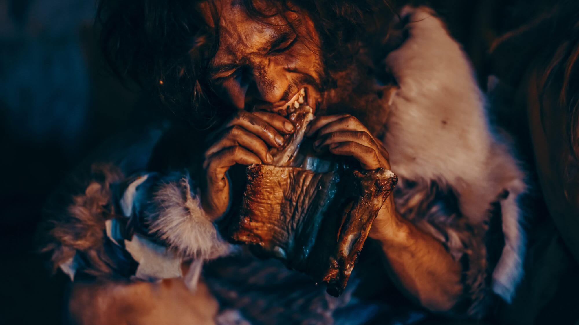 Recreación de un hombre comiendo en época prehistórica