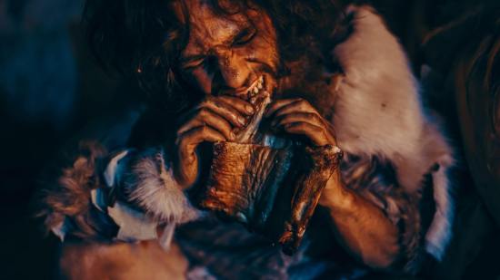 Recreación de un hombre comiendo en época prehistórica