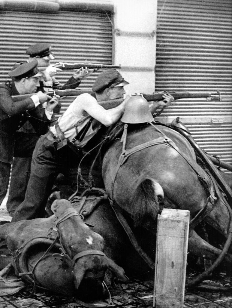 Combatientes republicanos tras una barricada de caballos en Barcelona en 1937