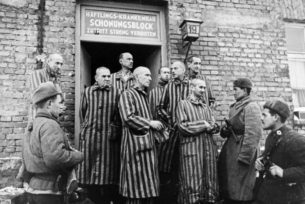 Soldados del Ejército Rojo posan junto a prisioneros liberados del campo de concentración de Auschwitz en una fotografía tomada en 1945