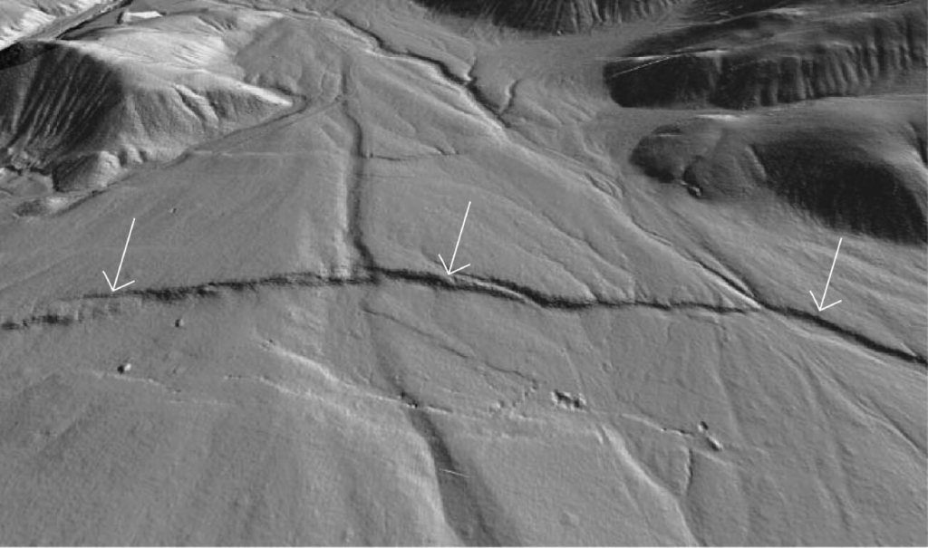 Figura 2: Así es como se ve el relieve actualmente en un sector del Owens valley (California) debido a la ruptura que generó el terremoto de 1872. Es un modelo digital del terreno construido con datos LIDAR en que se aprecia como la falla al moverse generó varios escalones (escarpes) de ruptura (flechas blancas) cruzando un abanico aluvial. Figura modificada de Haddon et al. (2016)