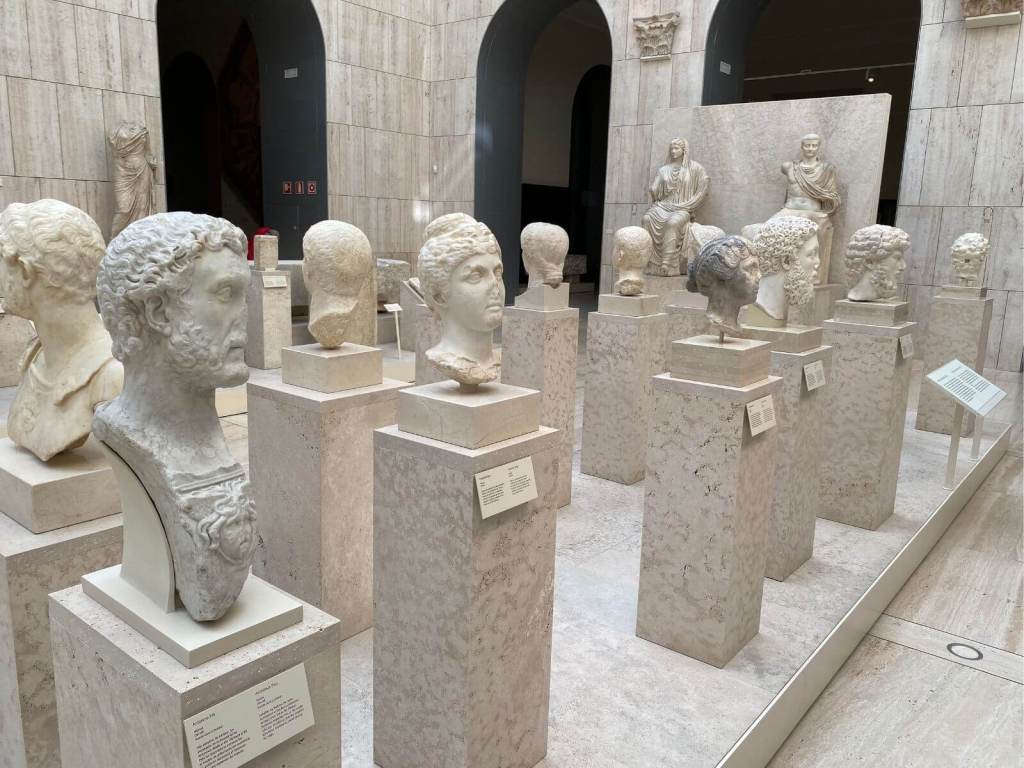 5. Retratos romanos en el Museo Arqueológico Nacional, Madrid. Foto propia. Mientras paseamos por la Plaza de Colón o por la calle Serrano, podemos entrar unos instantes al MAN en Madrid y toparnos con rostros de notables, aristócratas y emperadores romanos que quedaron inmortalizados en piedra en Hispania. Son el eco en piedra de un mundo que se fue, pero que aún flota en nuestra atmósfera.
