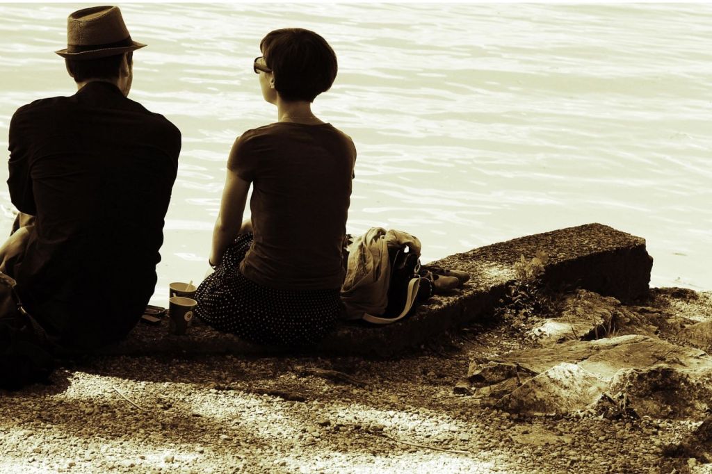 Pareja sentada junto a un lago